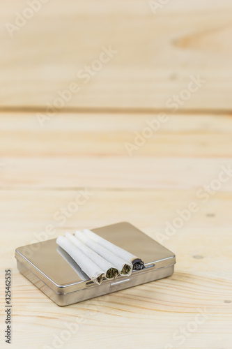 Hashish joint on wooden background cigarette box for smoking.