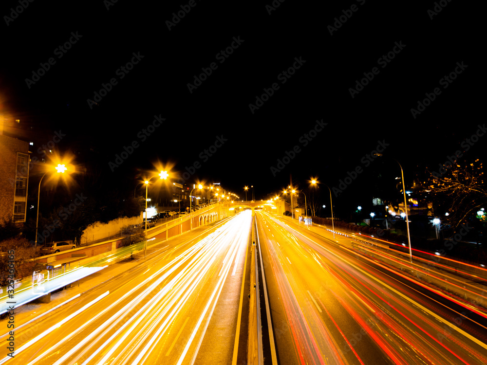 line of night lights on a road by cars with long exposure.