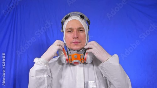 Scientist virologist in respirator. Slow motion. Man close up look, wearing protective medical mask. Concept health safety N1H1 virus protection coronavirus epidemic 2019 nCoV. Chroma key blue film. photo