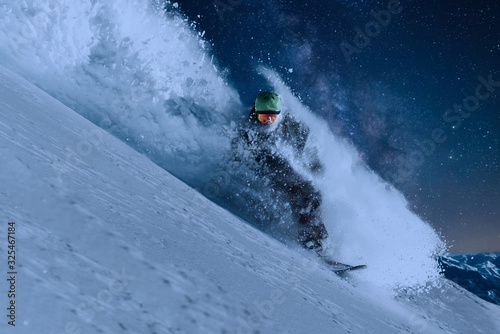 фотография night skating snowboarder is going very fast in stream of snow avalanche under t