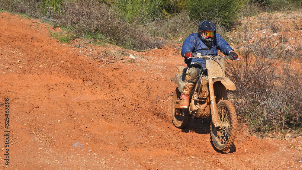 Zoom photo of unidentified motocross rider performing extreme stunts in off road dirt track Zoom photo of unidentified motocross rider performing extreme stunts in off road dirt track