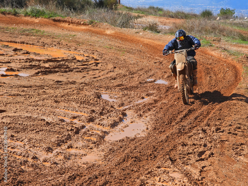 Zoom photo of unidentified motocross rider performing extreme stunts in off road dirt track