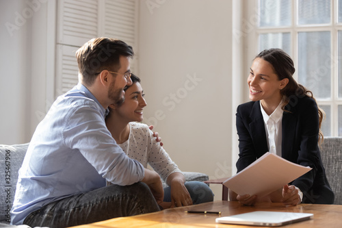 Fotografiet Client and banker seated on sofa discuss mortgage contract terms