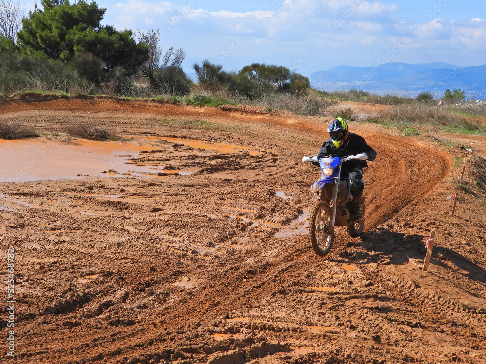 Zoom photo of unidentified motocross rider performing extreme stunts in off road dirt track Zoom photo of unidentified motocross rider performing extreme stunts in off road dirt track