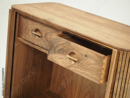 Original designer chest of drawers made of natural wood in its entirety, as well as its details on a white background, from different angles.