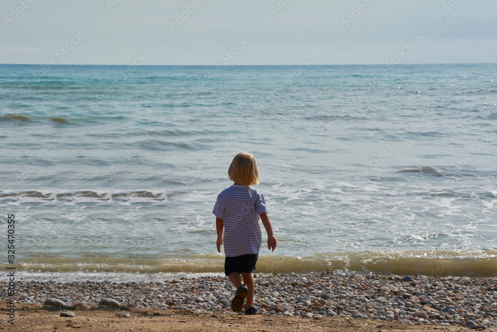 Children looking at the calm and blue beach