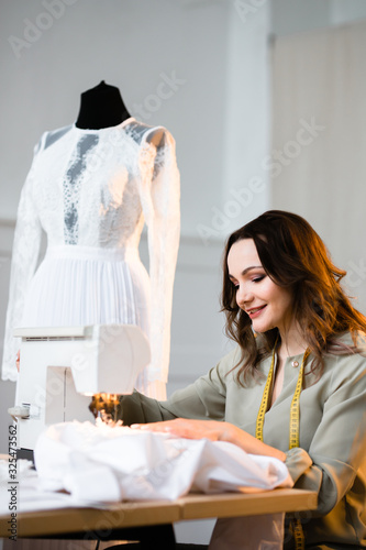 Fotografie Beautiful girl learns to sew
