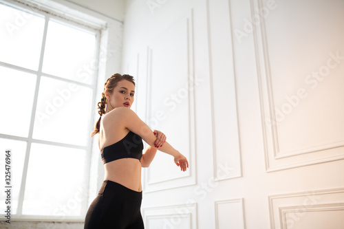 A female trainer shows an exercise from a Pilates complex. Wellness exercise for the back.