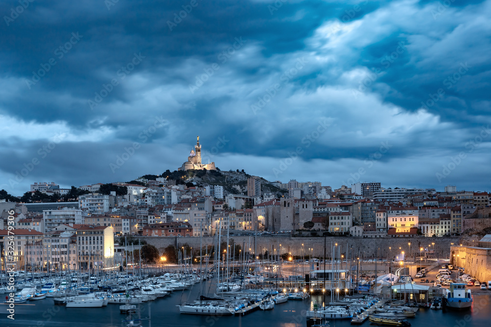 Fototapeta premium Night Old Port and the Basilica of Notre Dame de la Garde on the background, on the hill, Marseille, France