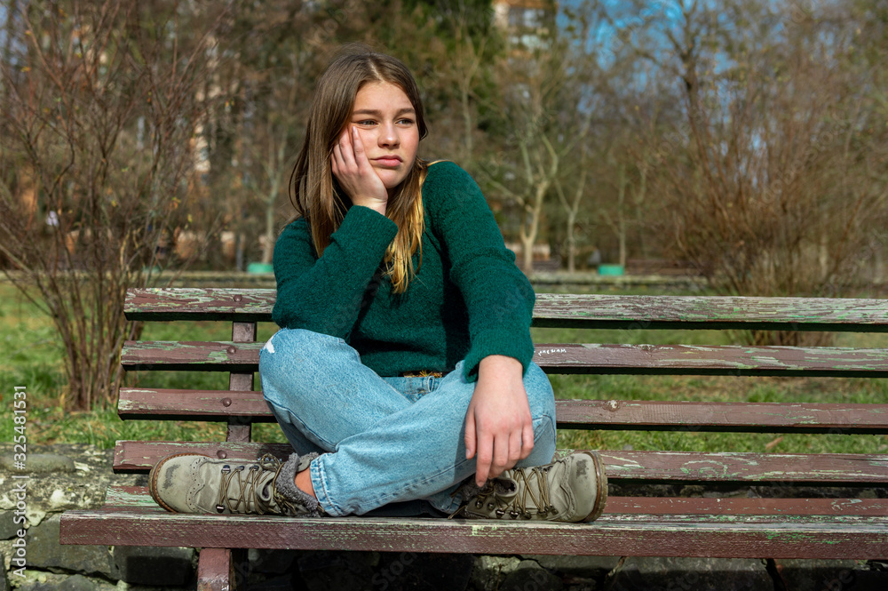 sad teenager girl sitting in the park sad teenager girl sitting in the park