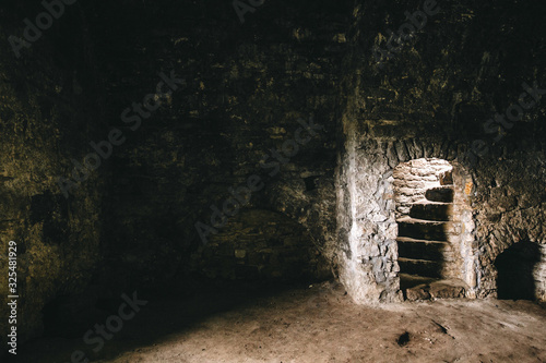 Inside of ruins of Chortkiv castle, Ukraine. Destroyed ruined brick walls and window light in dark indoors of medieval castle, historical defence fortress in Europe photo