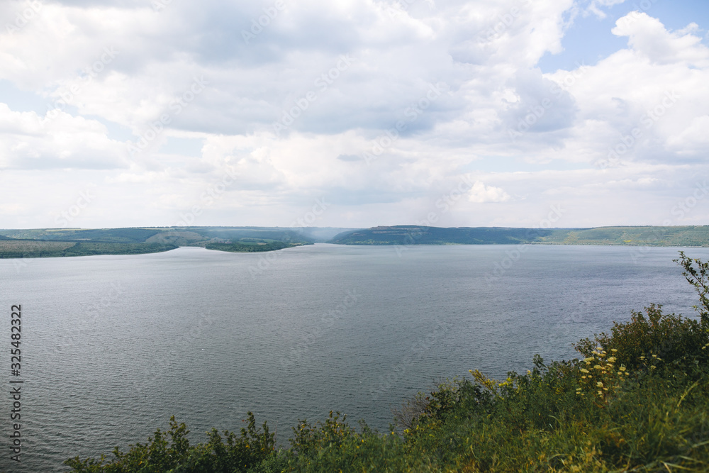 Beautiful view on big lake among hills. River and cliffs landscape. Bakota lake and Dnister river in Ukraine. Travelling and exploring national park. Camping on summer vacation