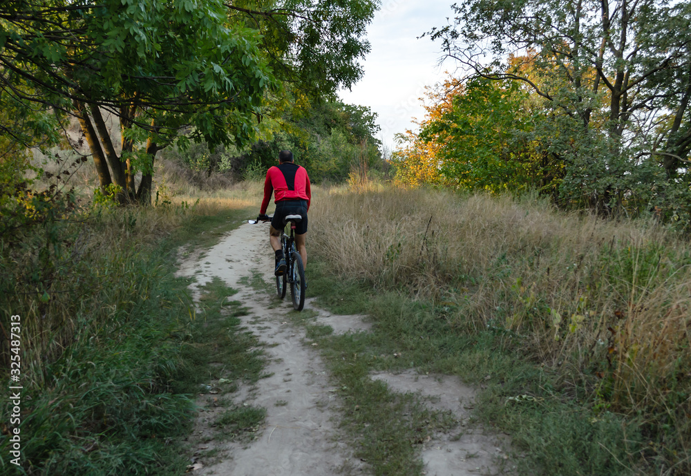 cyclist rides on a country path, outdoor activities cyclist rides on a country path, outdoor activities