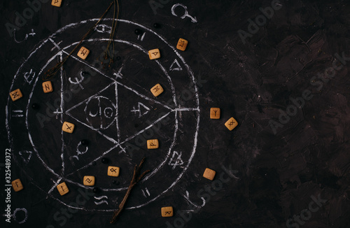 Fotografie Open old book with magic spells, runes, black candles on witch table
