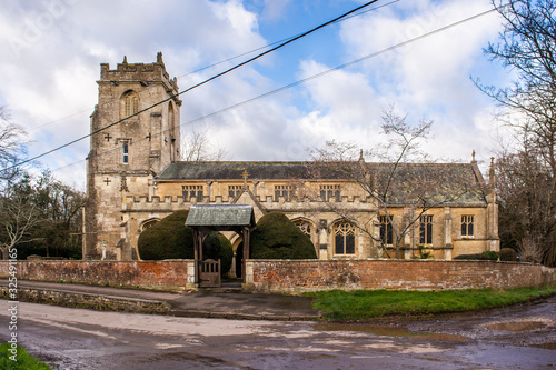 St Katharine's church in the village of Holt in Wiltshire with a lychgate and path through yew bushes to the door