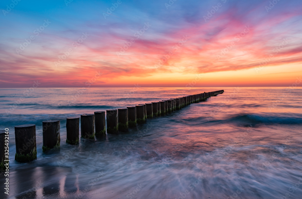 Baltic sea seascape at sunset, Poland, wooden breakwater and waves - obrazy, fototapety, plakaty 