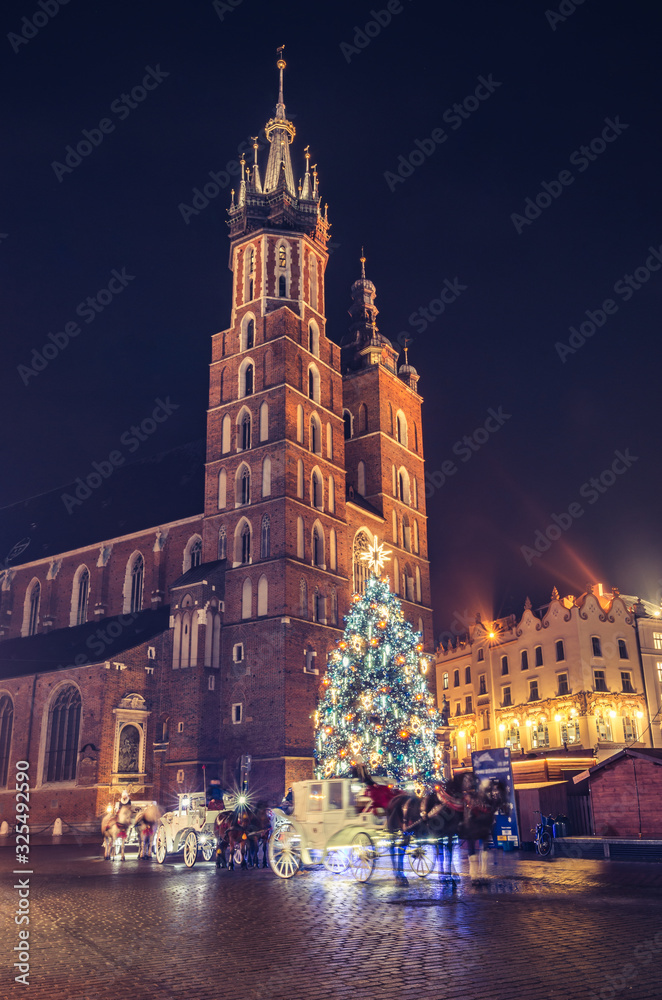 Fototapeta premium Krakow, Poland, Christmas tree on Main Square and St Mary's church