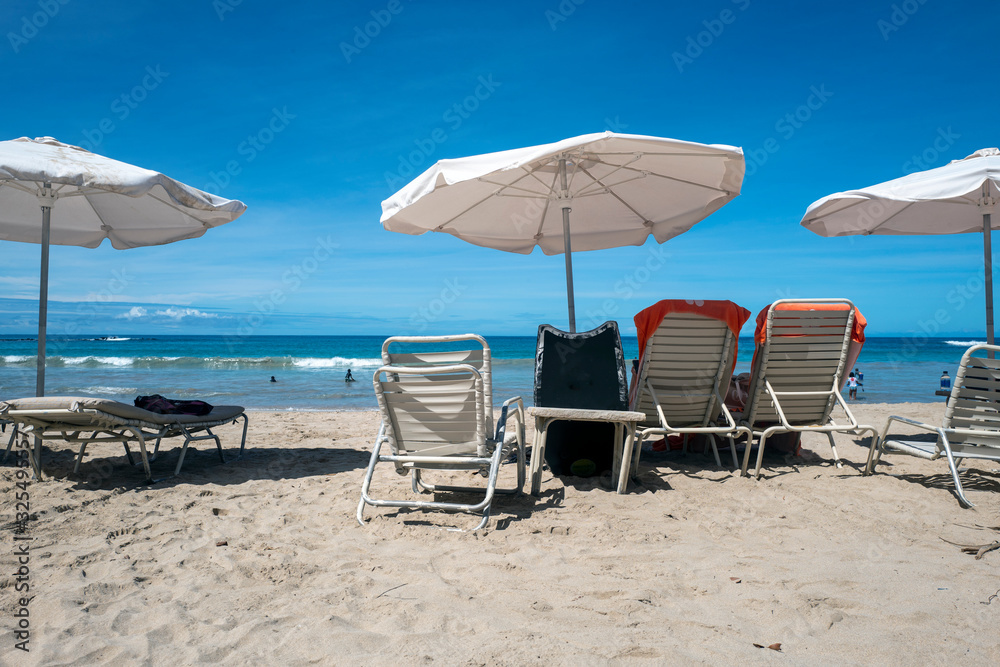 umbrellas and. chairs on a beach with waves and sand