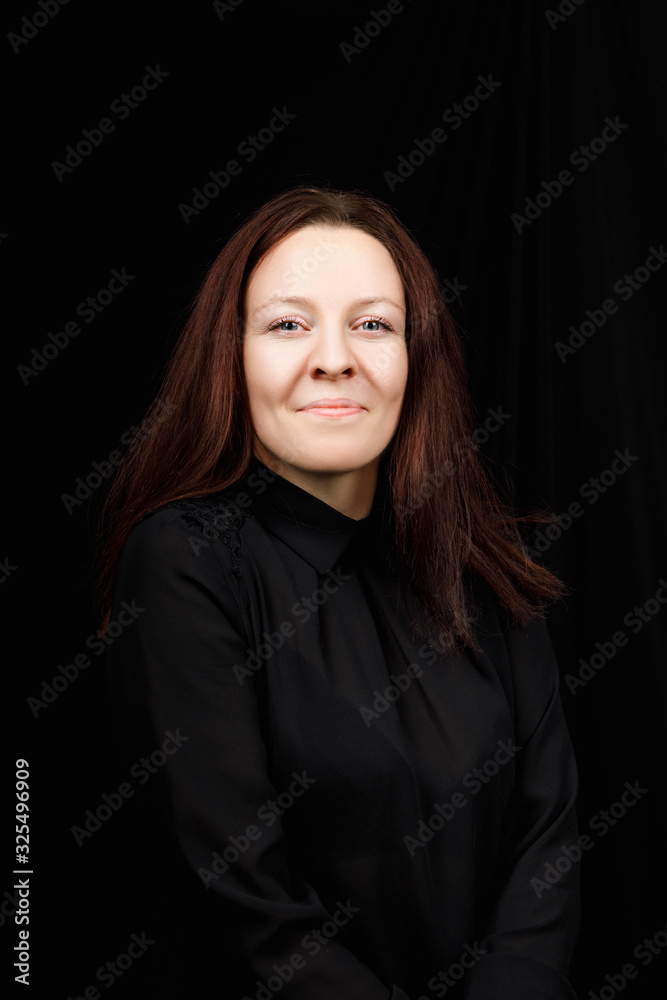 Portrait of successful business woman in
a black shirt with crossed hands on black background Portrait of successful business woman in
a black shirt with crossed hands on black background