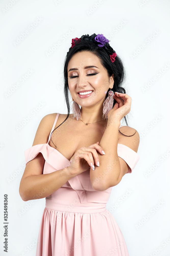 Fashion portrait young brunette girl with closed eyes wearing stylish pink dress with a hoop on her head. Studio shot on white background. Fashion portrait young brunette girl with closed eyes wearing stylish pink dress with a hoop on her head. Studio shot on white background.