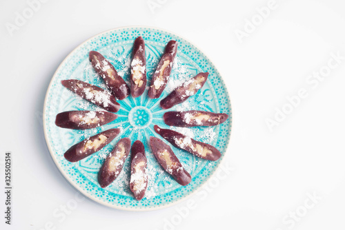 churchkhela sprinkled with icing sugar on a plate with oriental-style ornament