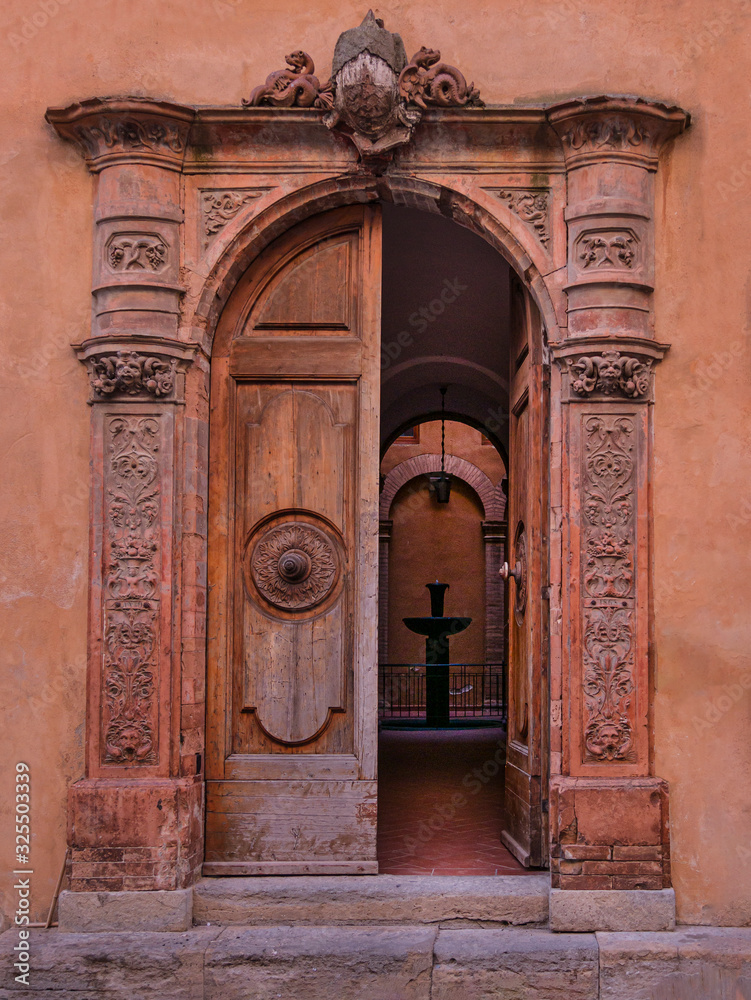 Entrance door of an ancient and prestigious building in the center of the city of Volterra in Tuscany (Italy)