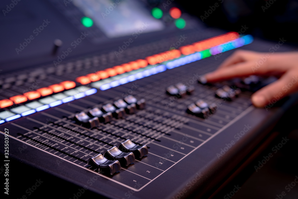 Close up of audio mixing desk with blurred lights