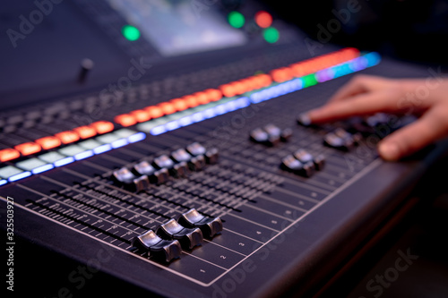 Close up of audio mixing desk with blurred lights
