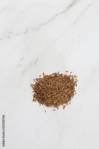 Pile of cumin seeds captured from above isolated on white. Seeds of caraway, also known as meridian fennel and Persian cumin. Aromatic carminative. Concept of health and food