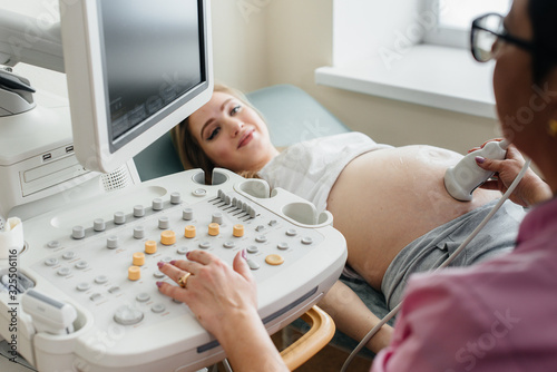 Close-up ultrasound device during a medical examination of a pregnant woman. Medical examination