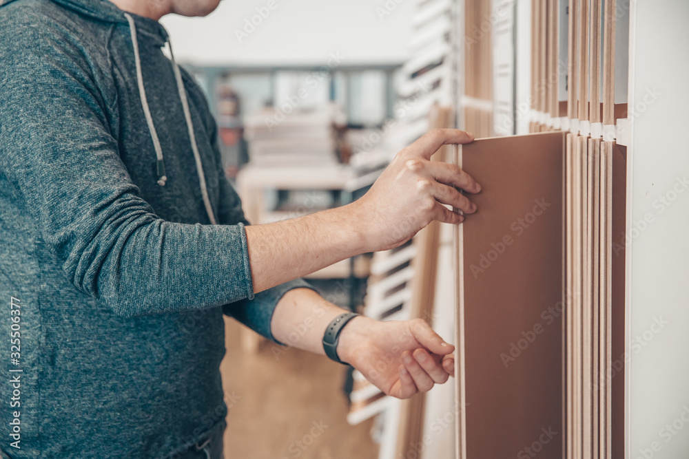 Obraz premium Male selects wooden floor of the sample in the specialized trade