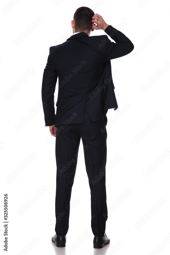Rear view of a confused businessman scratching his head Rear view of a confused businessman scratching his head