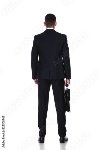 Rear view of confident businessman holding briefcase