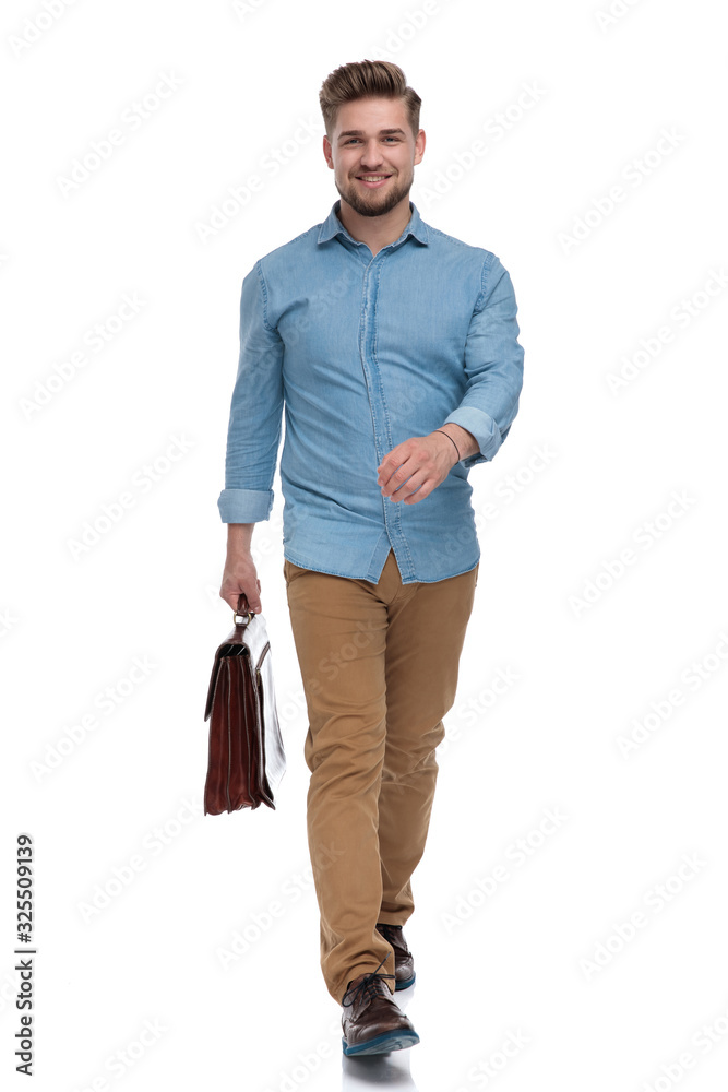 Confident casual man smiling while holding briefcase