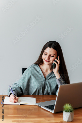 Young attractive girl takes calls in the office