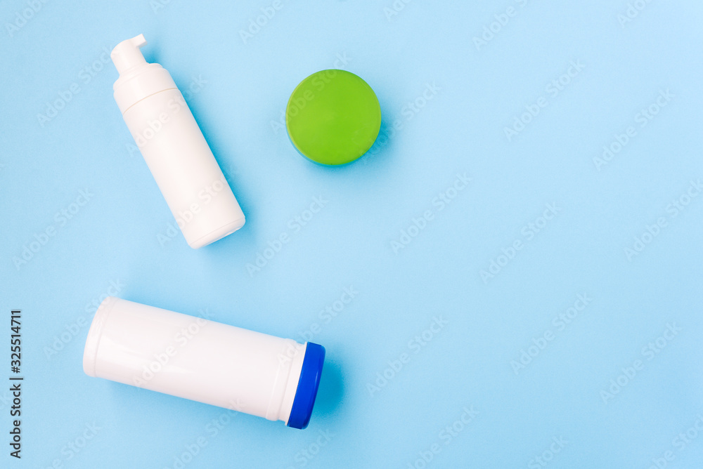 Cosmetic products on a blue background. Face foam, cream and a napkin can. Body and skin care. Beauty salon, spa concept. Cosmetic products on a blue background. Face foam, cream and a napkin can. Body and skin care. Beauty salon, spa concept.