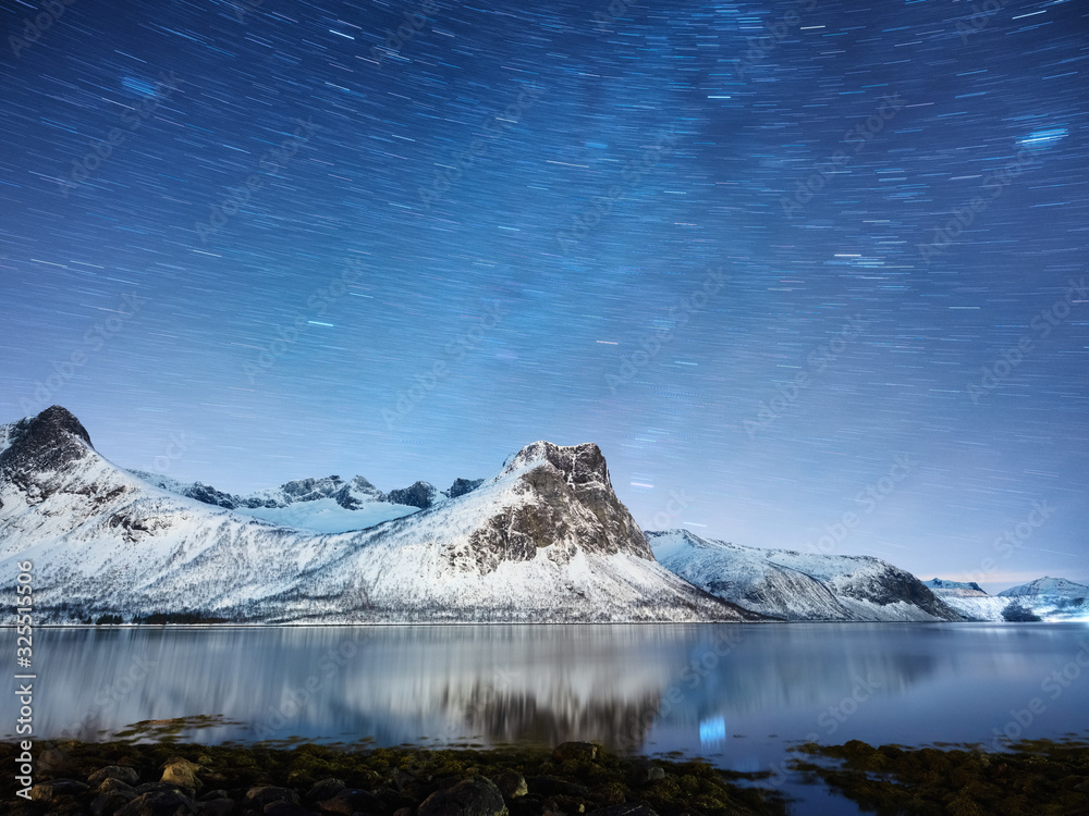 Mountains and starry night sky, Senja islands, Norway. Reflection on the water surface. Winter landscape with night sky. Norway travel - image