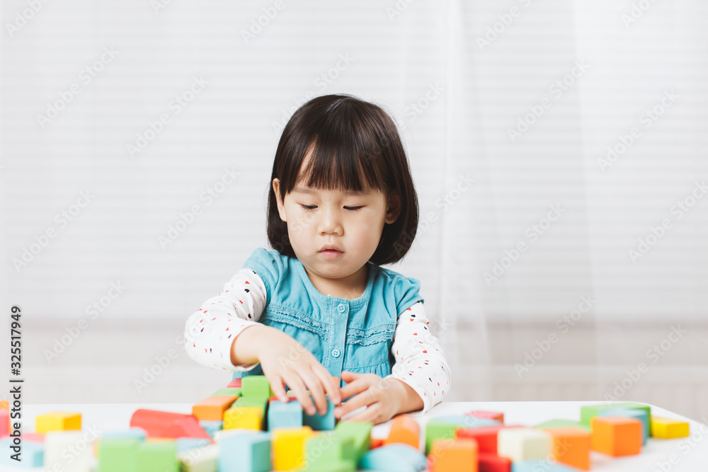 toddler girl playing creative toy blocks at home against white background toddler girl playing creative toy blocks at home against white background