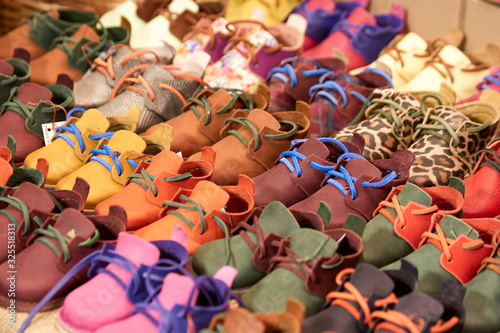 Many children shoes pairs. Row of various colorful boots for kids.