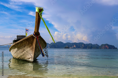 The traditional Thai long boat on the beach at Koh Samui, Thailand. On a boat trip at the small islands around Kohsamui, beautiful holiday destination south east Asia. Blue sky and some white clouds 