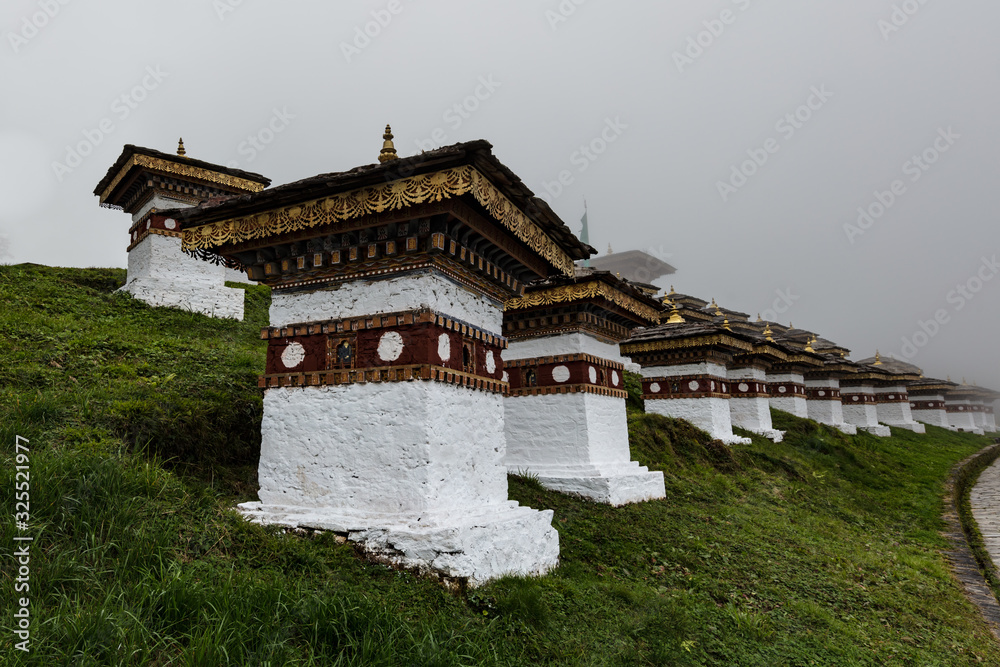 Druk Wangyal, Bhutan, 108 chorten or stupas, a memorial in honor of the Bhutanese soldiers at the Dochula Pass on a cloudy foggy day in altitude of 3000 meters. A bhutanese sanctuary Druk Wangyal, Bhutan, 108 chorten or stupas, a memorial in honor of the Bhutanese soldiers at the Dochula Pass on a cloudy foggy day in altitude of 3000 meters. A bhutanese sanctuary