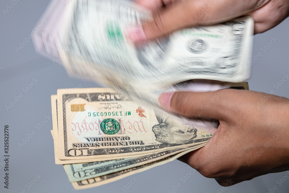 Foto de Female hands counting US dollars. 10 and 20 Dollar is after the