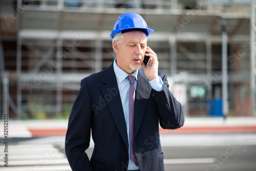 Architect talking on the cellphone in front of construction site