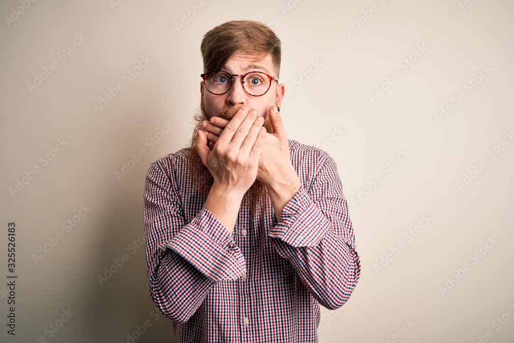 Handsome Irish redhead business man with beard wearing glasses over isolated background shocked covering mouth with hands for mistake. Secret concept. Handsome Irish redhead business man with beard wearing glasses over isolated background shocked covering mouth with hands for mistake. Secret concept.