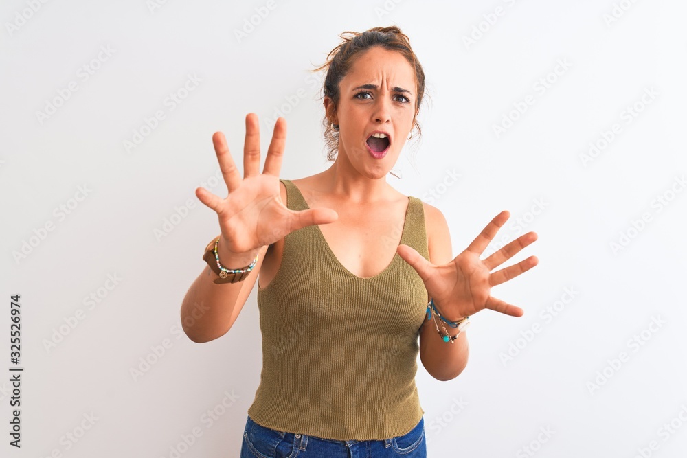 Young redhead woman wearing a bun over isolated background afraid and terrified with fear expression stop gesture with hands, shouting in shock. Panic concept. Young redhead woman wearing a bun over isolated background afraid and terrified with fear expression stop gesture with hands, shouting in shock. Panic concept.