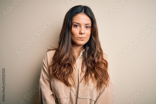 Young beautiful brunette woman wearing casual shirt standing over white background skeptic and nervous, frowning upset because of problem. Negative person.