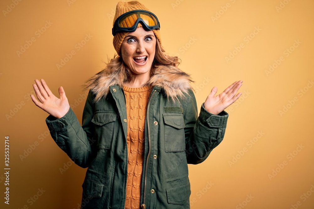 Middle age beautiful blonde skier woman wearing snow sportwear and ski goggles celebrating crazy and amazed for success with arms raised and open eyes screaming excited. Winner concept Middle age beautiful blonde skier woman wearing snow sportwear and ski goggles celebrating crazy and amazed for success with arms raised and open eyes screaming excited. Winner concept