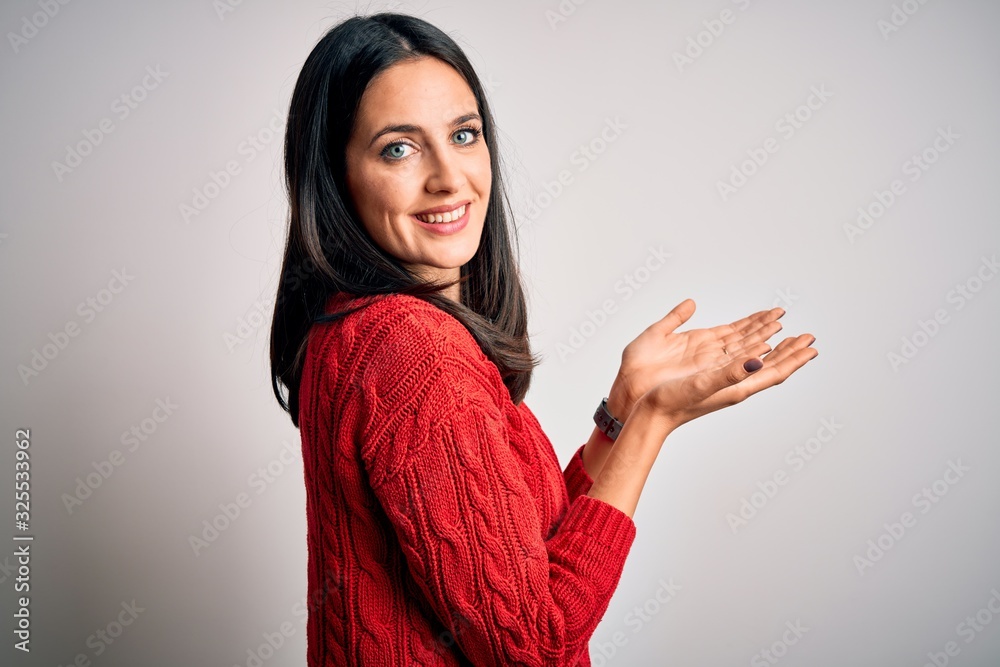 Young brunette woman with blue eyes wearing casual sweater over isolated white background pointing aside with hands open palms showing copy space, presenting advertisement smiling excited happy Young brunette woman with blue eyes wearing casual sweater over isolated white background pointing aside with hands open palms showing copy space, presenting advertisement smiling excited happy