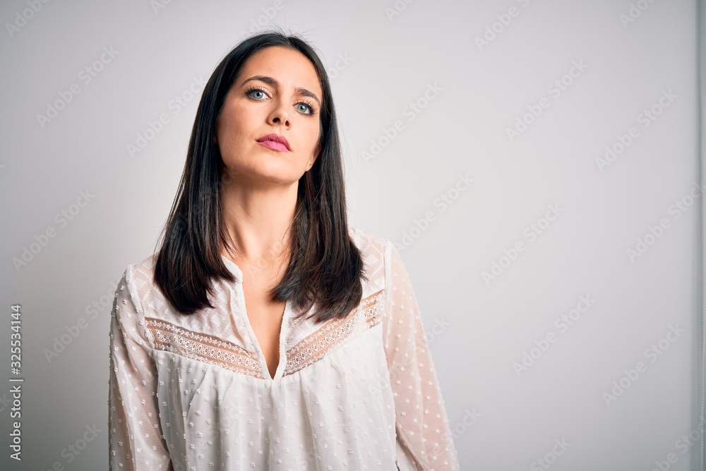 Young brunette woman with blue eyes wearing casual t-shirt over isolated white background Relaxed with serious expression on face. Simple and natural looking at the camera. Young brunette woman with blue eyes wearing casual t-shirt over isolated white background Relaxed with serious expression on face. Simple and natural looking at the camera.