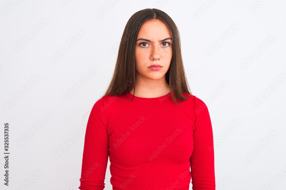 Young beautiful girl wearing red casual t-shirt standing over isolated white background skeptic and nervous, frowning upset because of problem. Negative person. Young beautiful girl wearing red casual t-shirt standing over isolated white background skeptic and nervous, frowning upset because of problem. Negative person.